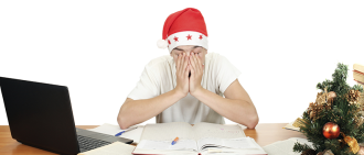 Sleepy student wearing santa hat while studying