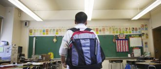 boy wearing backpack in school