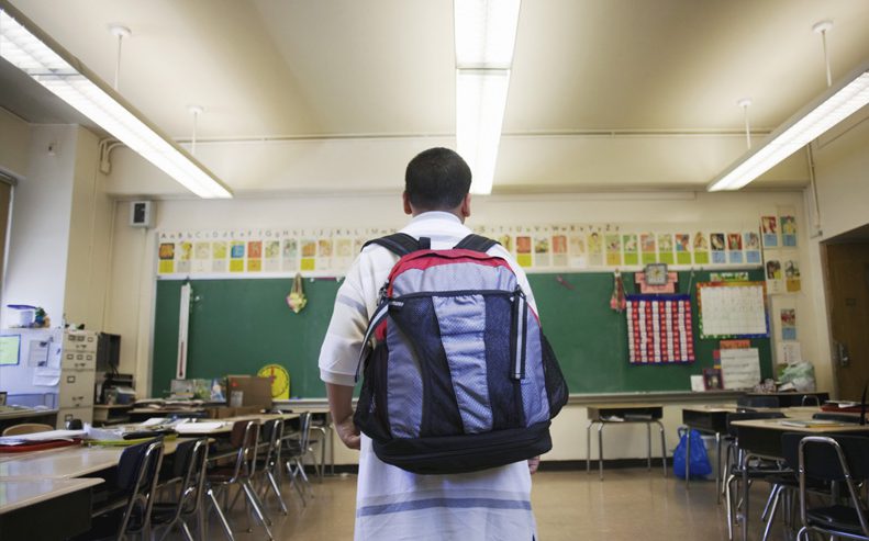 boy wearing backpack in school