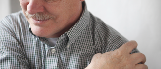man clutching sore shoulder
