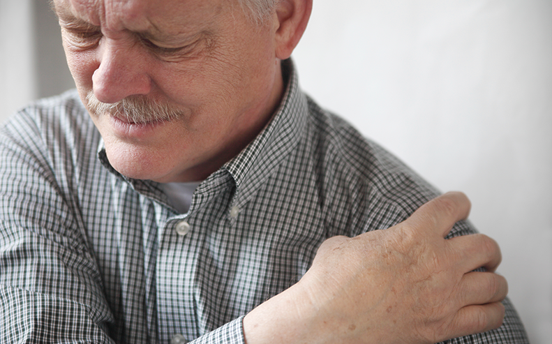 man clutching sore shoulder