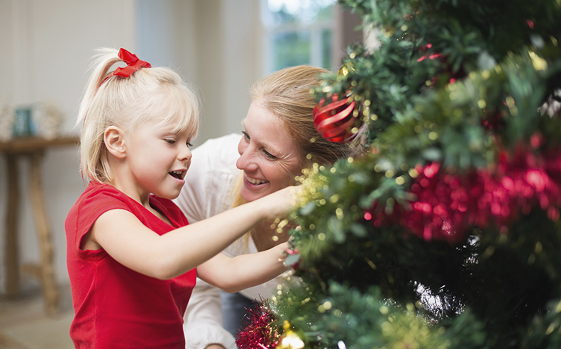 girl and mother by Christmas tree