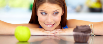 woman choosing between apple and cupcake