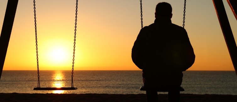 Lonely man looking out a water