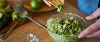 dipping a tortilla chip in guac