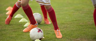 A player kicks a soccer ball during a game.