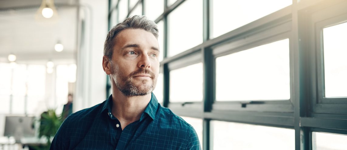 A man looks out a window.