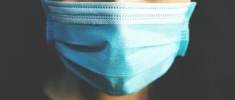 A close-up photo of a person wearing a facemask.