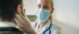 Female Doctor wearing a mask treating patient
