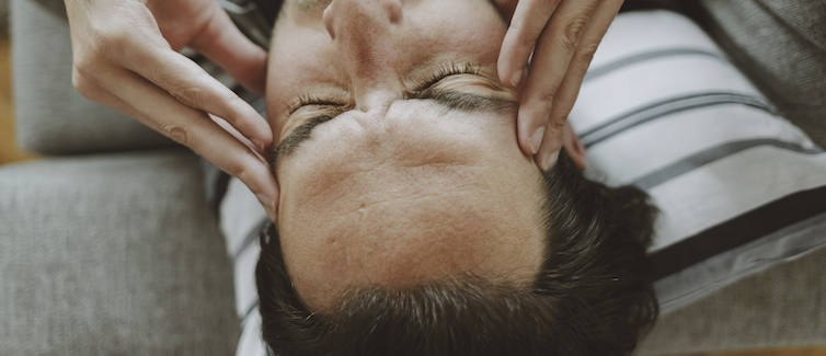 A person rubs their temples during a headache.