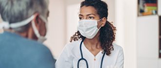 A doctor greets a patient in this photo.