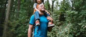 Father Carries Son On Hike