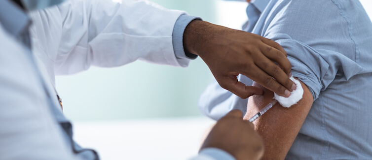 Mature man taking a vaccine from his doctor