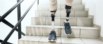 Man with prosthetic legs going down the stairs