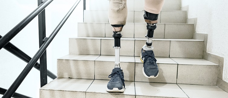 Man with prosthetic legs going down the stairs