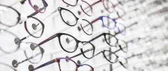 Large group of eyeglasses in an eyewear store display.